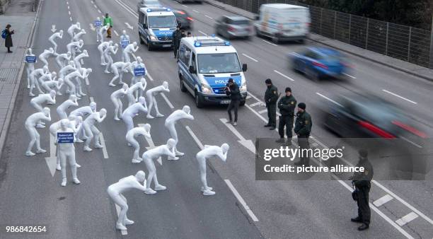 Dpatop - Police officers stand guard as activists from Greenpeace organization wear white suits during a protest action against health burden caused...