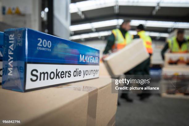 Dpatop - 19 February 2018, Germany, Kiel: Cartons filled with smuggled cigarettes and some pet litter for disguise can be seen in front of a truck....