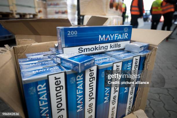 February 2018, Germany, Kiel: Cartons filled with smuggled cigarettes and some pet litter for disguise can be seen in front of a truck. The customs...