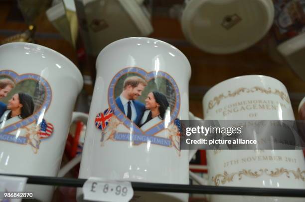 Febuary 2018, England, Windsor: Mugs with the image of Prince Harry and Meghan Markle standing on a shelf in a souvenir shop. Photo: Christoph...