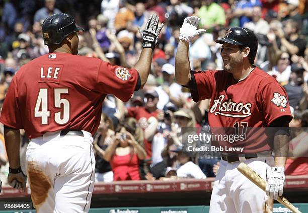 Carlos Lee of the Houston Astros receives a high five from Lance Berkman after he was awarded home plate after hitting a triple and the ball was...