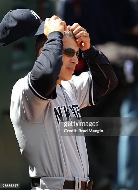Manager Joe Girardi of the New York Yankees scratches his head in the dugout during the game between the New York Yankees and the Oakland Athletics...