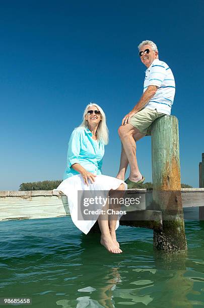 retired couple smiling on a boat dock - anna maria island stock pictures, royalty-free photos & images