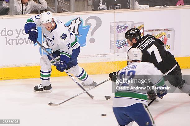 Henrik Sedin of the Vancouver Canucks skates with the puck against Rob Scuderi of the Los Angeles Kings in Game Six of the Western Conference...