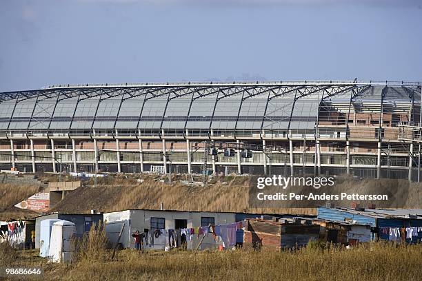 Poor shantytown is seen in front of the newly constructed Orlando Stadium on June 21, 2008 in Soweto, South Africa. Many people still live in poverty...