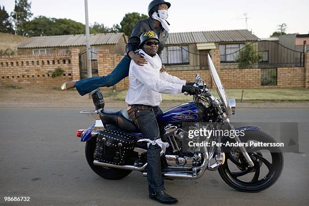 Afrika Tau, age 31, picks up a friend with his Harley Davidson motorcycle on March 8, 2009 in Soweto, South Africa. He grew up in Soweto and he is...