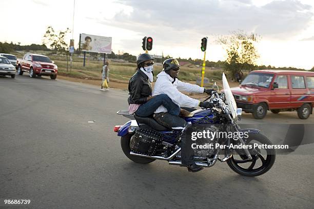 Afrika Tau, age 31, rides with a friend on his Harley Davidson motorcycle on March 8, 2009 in Soweto, South Africa. He grew up in Soweto and he is...