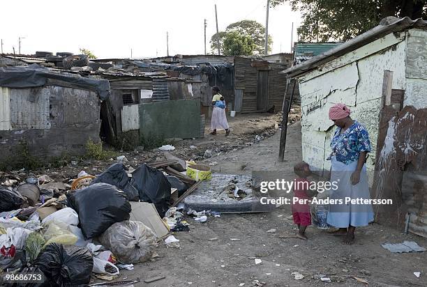 Mother stands with her son outside their shack on March 9 in Duncan Village a poor township outside East London, South Africa. This area is one of...