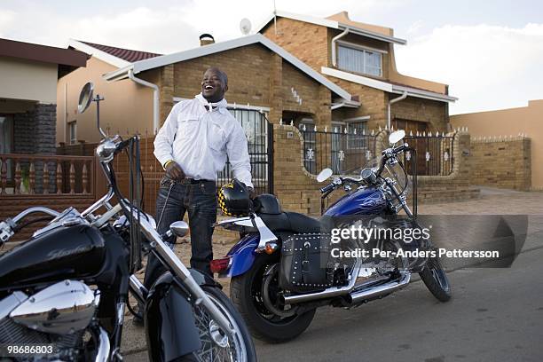 Afrika Tau, age 31, waits to pick up a friend with his Harley Davidson motorcycle on March 8, 2009 in Soweto, South Africa. He grew up in Soweto and...