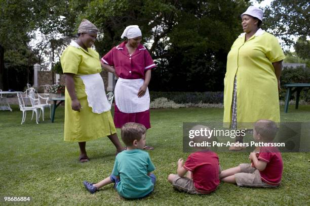 Black female servants talk to white boys during a sheep auction on February 24, 2009 in Philippolis, in the free state province, South Africa. The...