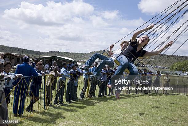 White children ride carnival rides as poor black children watch on March 13, 2009 in Philippolis, in the Free state province, South Africa. The...