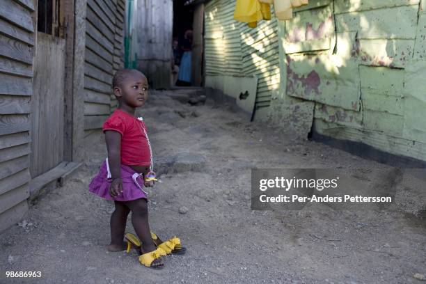 Young girl plays with her mothers shoes outside the family home on March 10 in Duncan Village a poor township outside East London, South Africa. This...