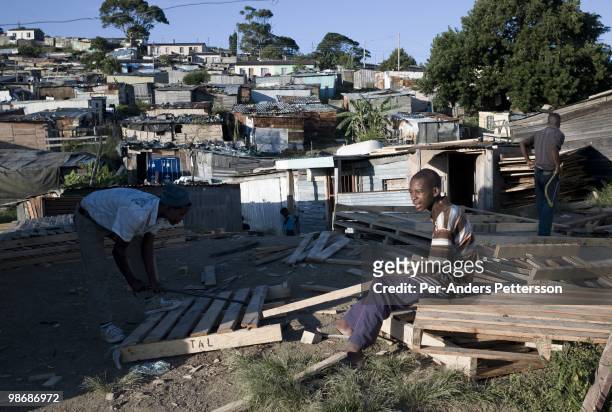 Young men build and sell wooden shacks on March 9 in Duncan Village a poor township outside East London, South Africa. This area is one of the most...