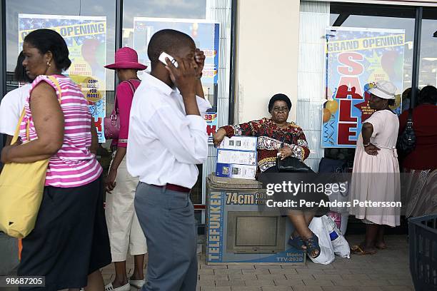 Woman rests on a big box with a television during an opening of the Jabulani shopping mall on October 26, 2006 in Soweto, Johannesburg, South Africa....