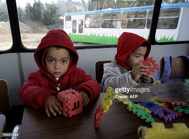 Children play in class on April 26, 2010 at the "bus school" where the private school Mis Sonidos is working following its devastation on the quake...