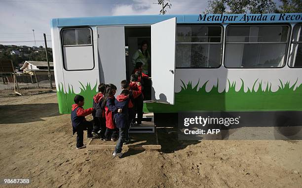 Children get into the class on April 26, 2010 at the "bus school" where the private school Mis Sonidos is working following its devastation on the...