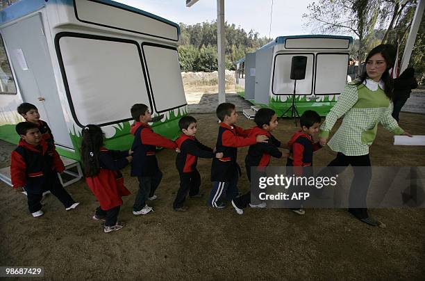 Children get into the class on April 26, 2010 at the "bus school" where the private school Mis Sonidos is working following its devastation on the...