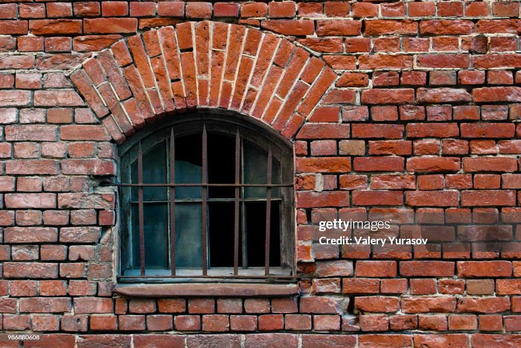 Part of the old wall of red brick with window and arch lattice. From the series window of Saint-Pete