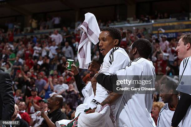 Brandon Jennings and Royal Ivey of the Milwaukee Bucks react to a basket by teammate Carlos Delfino against the Atlanta Hawks in Game Four of the...