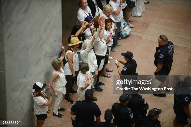 Capitol Police process a large group of mostly women demonstrators inside the Hart Senate office building in Washington, D.C., June 28 where they...