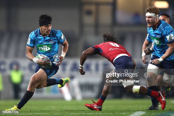 Reiko Ioane of the Blues is tackled during the round 17 Super Rugby match between the Blues and the Reds at Eden Park on June 29, 2018 in Auckland,...