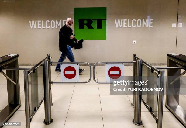 Picture taken on June 8, 2018 shows a man as he walks past a control post of the Russia Today TV company in Moscow.