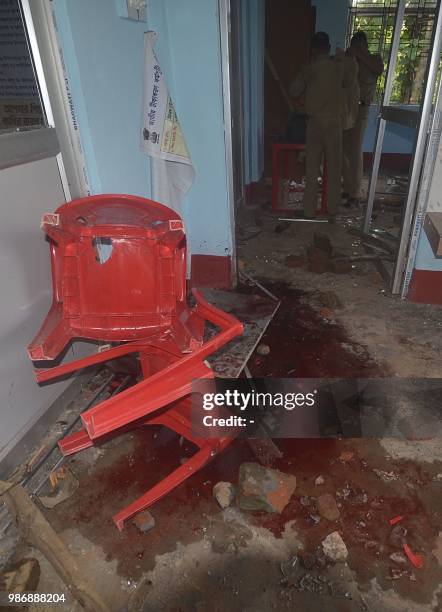 Indian paramilitary force personnel inspect a scene of a crime after an angry mob lynched one person and injuring others at a makeshift in Tripura...