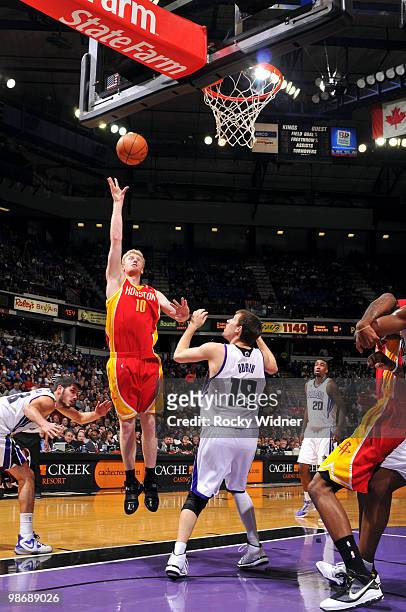 Chase Budinger of the Houston Rockets shoots a layup over Beno Udrih of the Sacramento Kings at Arco Arena on April 12, 2010 in Sacramento,...