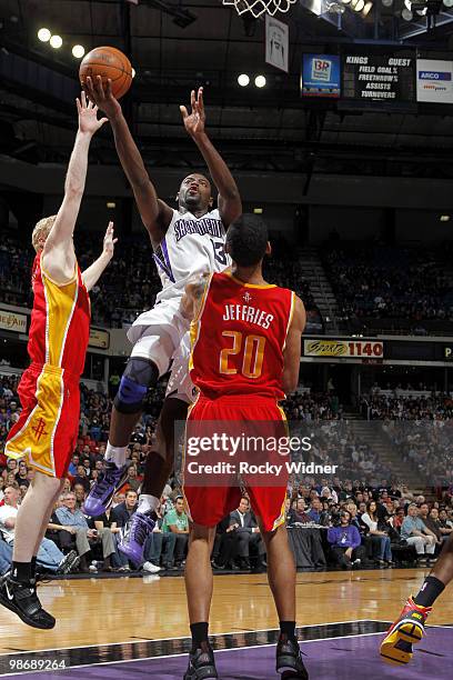 Tyreke Evans of the Sacramento Kings drives to the hoop between between Chase Budinger and Jared Jeffries of the Houston Rockets at Arco Arena on...