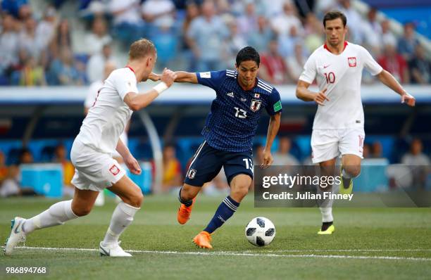 Yoshinori Muto of Japan goes past Kamil Glik of Poland during the 2018 FIFA World Cup Russia group H match between Japan and Poland at Volgograd...