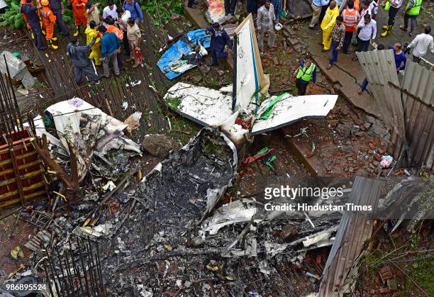 Forensic experts, fire department personnel and a dog squad inspect the wreckage of Beechcraft King Air C90 turboprop at Old Malik Estate, Jeev Daya...