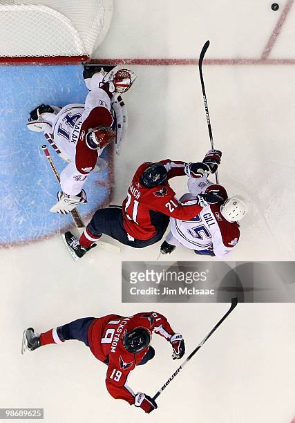Brooks Laich of the Washington Capitals skates for the puck against Jaroslav Halak and Hal Gill of the Montreal Canadiens in Game Five of the Eastern...
