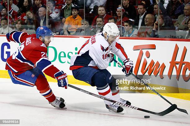 Eric Belanger of the Washington Capitals skates with the puck while being defended by Josh Gorges of the Montreal Canadiens in Game Six of the...