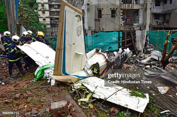 Fire department personnel inspect the wreckage of Beechcraft King Air C90 turboprop at Old Malik Estate, Jeev Daya Lane, near a telephone exchange at...