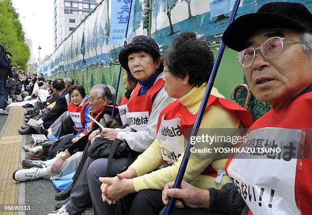 Some 100 Okinawan residents and their supporters stage a sit in protest against a US airbase in Okinawa during a rally in front of the National Diet...