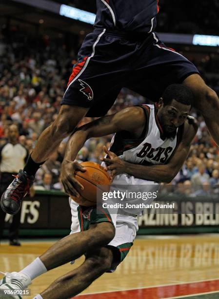 John Salmons of the Milwaukee Bucks ducks under a leaping Al Horford of the Atlanta Hawks as he drives to the basket in Game Four of the Eastern...