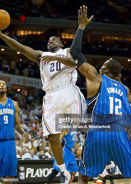 Raymond Felton of the Charlotte Bobcats drives to the basket past Dwight Howard of the Orlando Magic during first quarter action in Game Four of the...