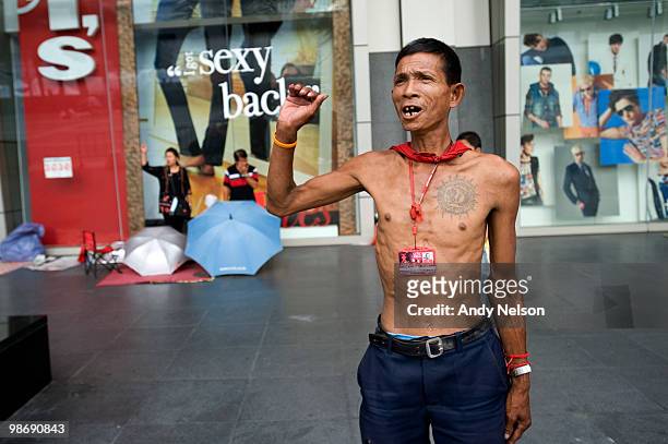 An anti-government protester cheers at the conclusion of the Thai National Anthem April 27, 2010 near his camp at the CentralWorld mall in Bangkok,...