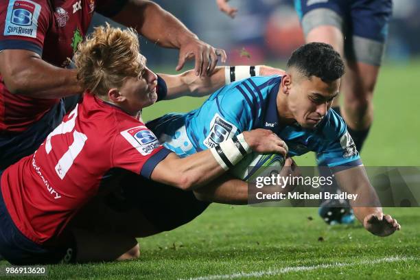 Blues Stephen Perofeta dives over for a try in the tackle of Reds Tate McDermott during the round 17 Super Rugby match between the Blues and the Reds...