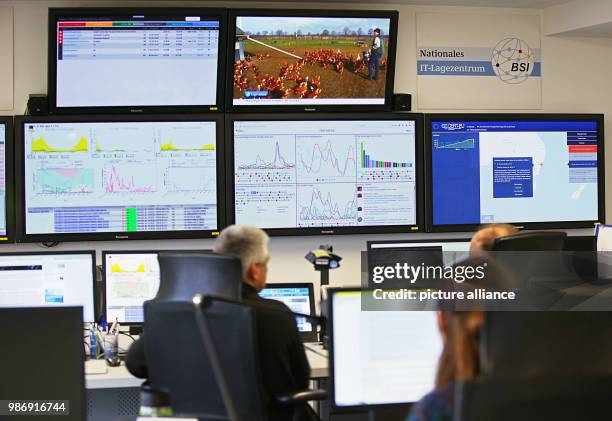 February 2018, Germany, Bonn: Employees of the Bundesamt für Sicherheit in der Informationstechnik sit in front of screens in the national IT centre....