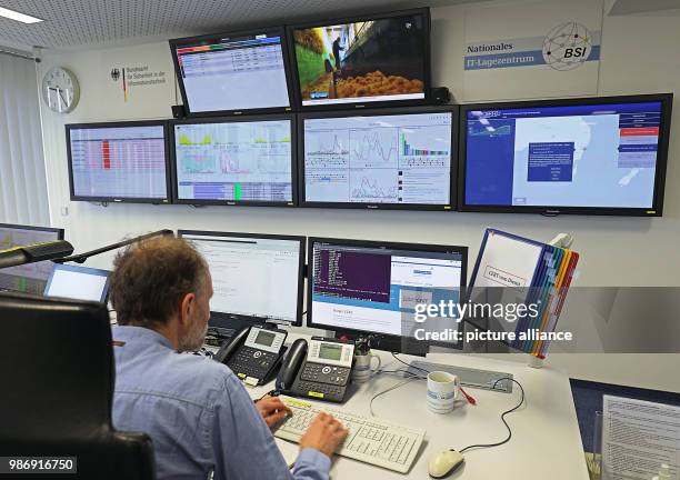 February 2018, Germany, Bonn: Employees of the Bundesamt für Sicherheit in der Informationstechnik sit in front of screens in the national IT centre....