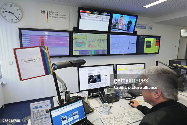 February 2018, Germany, Bonn: An employee of the Bundesamt für Sicherheit in der Informationstechnik sits in front of screens in the national IT...