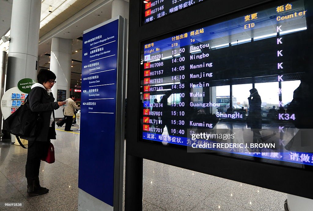 A traveller checks her ticket beside a f