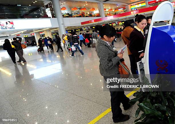 Traveller receives assistance from airline personel at an E-Ticket machine at Beijing's Capital International Airport, Terminal 1, on April 27, 2010....