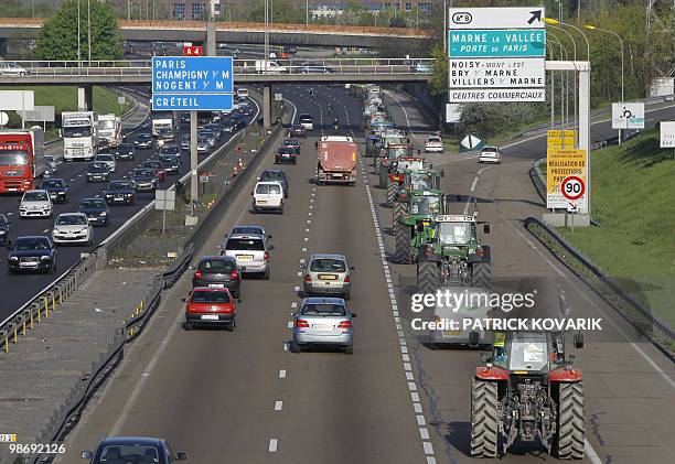 French farmers drive their tractors on a highway near Noisy-Le-Grand, east of Paris, on April 27, 2010 before demonstrating in Paris against wages...