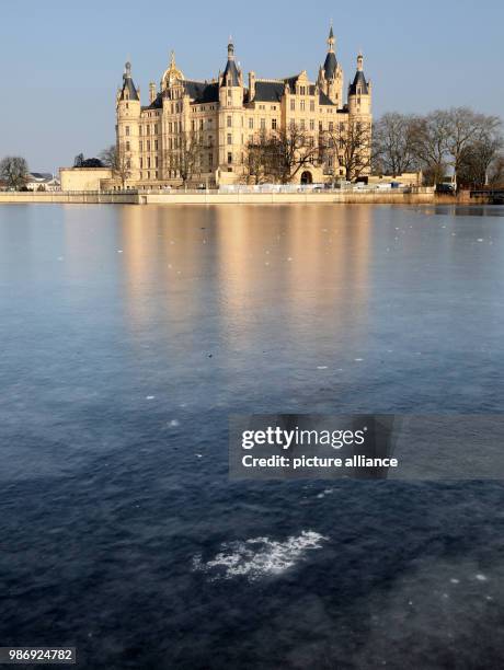 February 2018, Germany, Schwering: The Schwerin lake is covered with ice in front of the palace. Photo: Bernd Wüstneck/dpa-Zentralbild/dpa