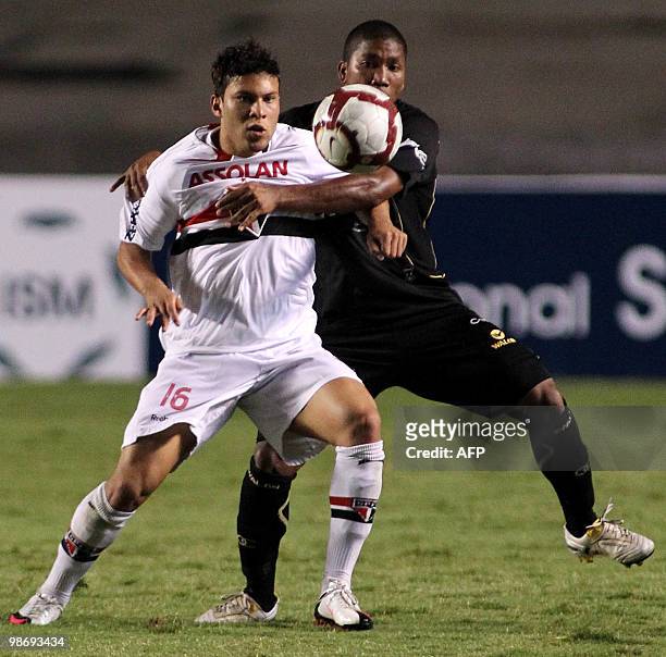 Marlos of Sao Paulo vies for the ball with Once Caldas player Nunes during their Copa Libertadores football match at the Morumbi stadium in Sao...