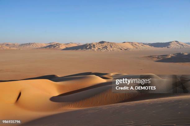 sultanate of oman, dhofar, rub al khali desert, called the empty quarter, the largest sand area in the world,border of yemen and saoudi arabia, a white 4 wheels is lost  in the middle of a ochre sand desert - dhofar stock pictures, royalty-free photos & images