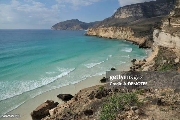 sultanate of oman, dhofar, limestone cliffs dropping into the turquoise blue indian ocean at fizayah west of salalah - dhofar stock pictures, royalty-free photos & images