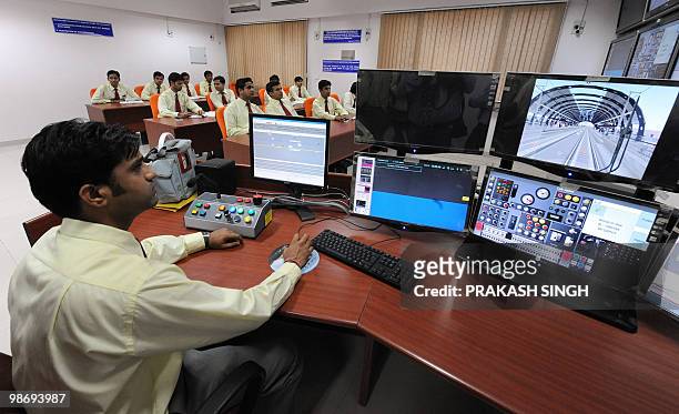 Training manager monitors the progress of a Delhi Metro Station Controller/Train Operator trainee using a train simulator at the Delhi Metro Training...